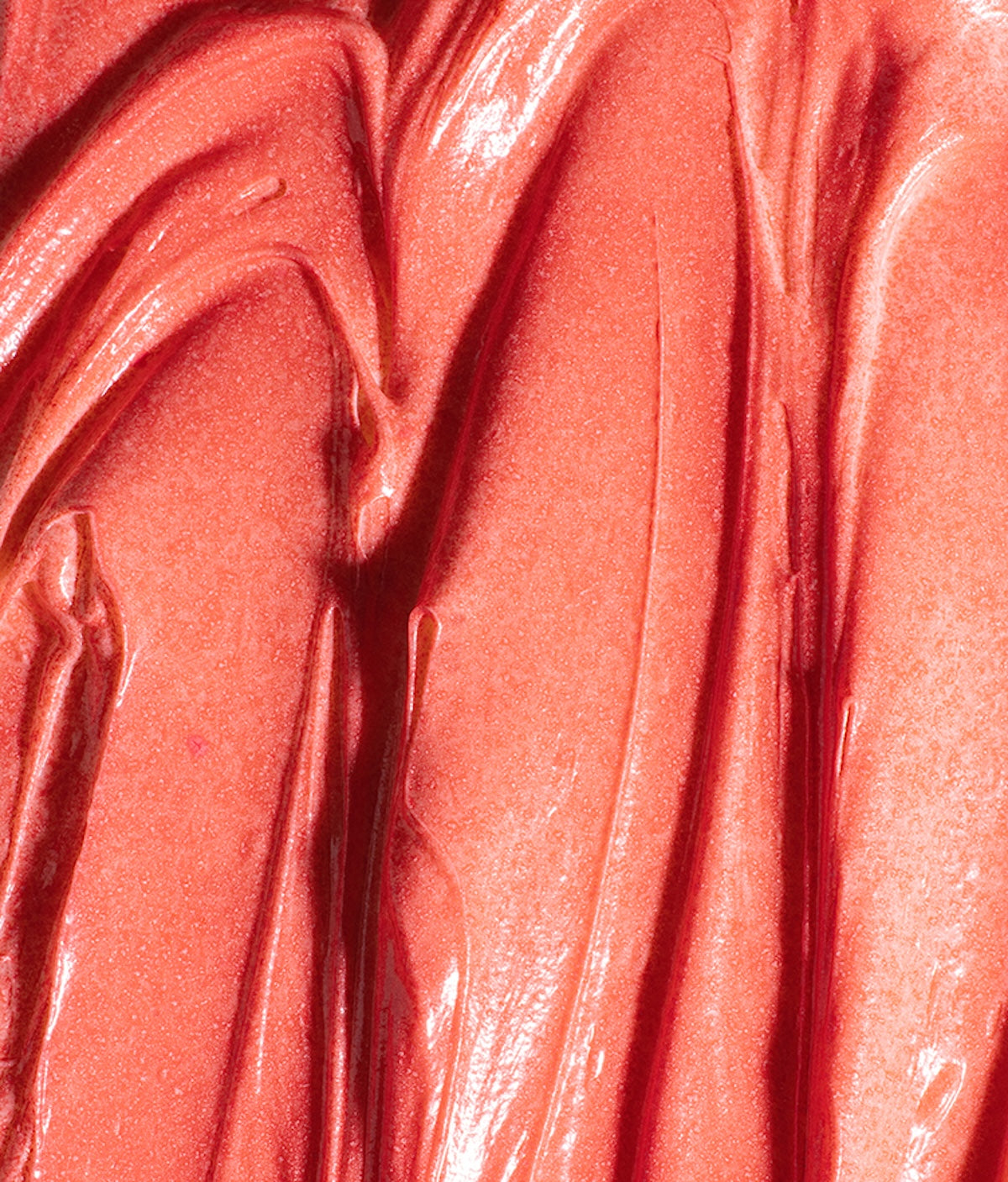 Close-up of Color Spray in Pinky Promise showcasing its coral pink glossy finish against a pink background