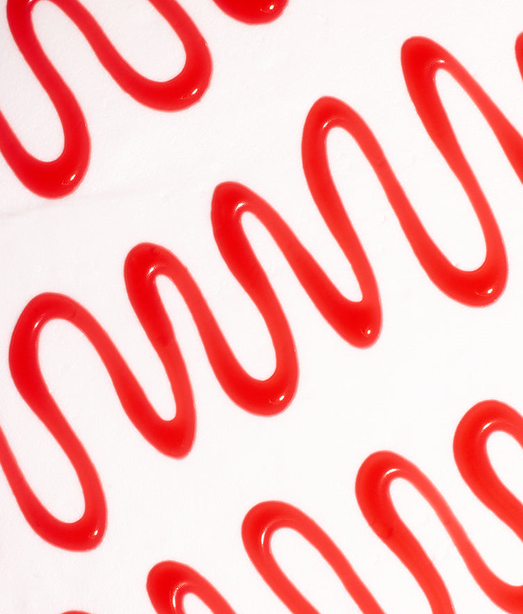 Close-up of Writing Gel Red showcasing glossy red gel in precise looping lines on a white background