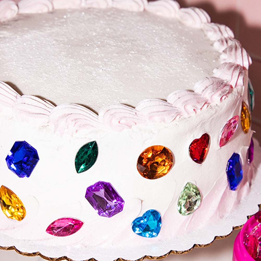 Close-up of a white frosted cake decorated with colorful faceted candy gems