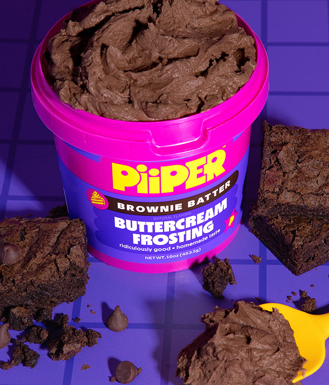 Front view of PiiPER Brownie Batter Buttercream Frosting showcasing thick frosting, brownies, and a purple background