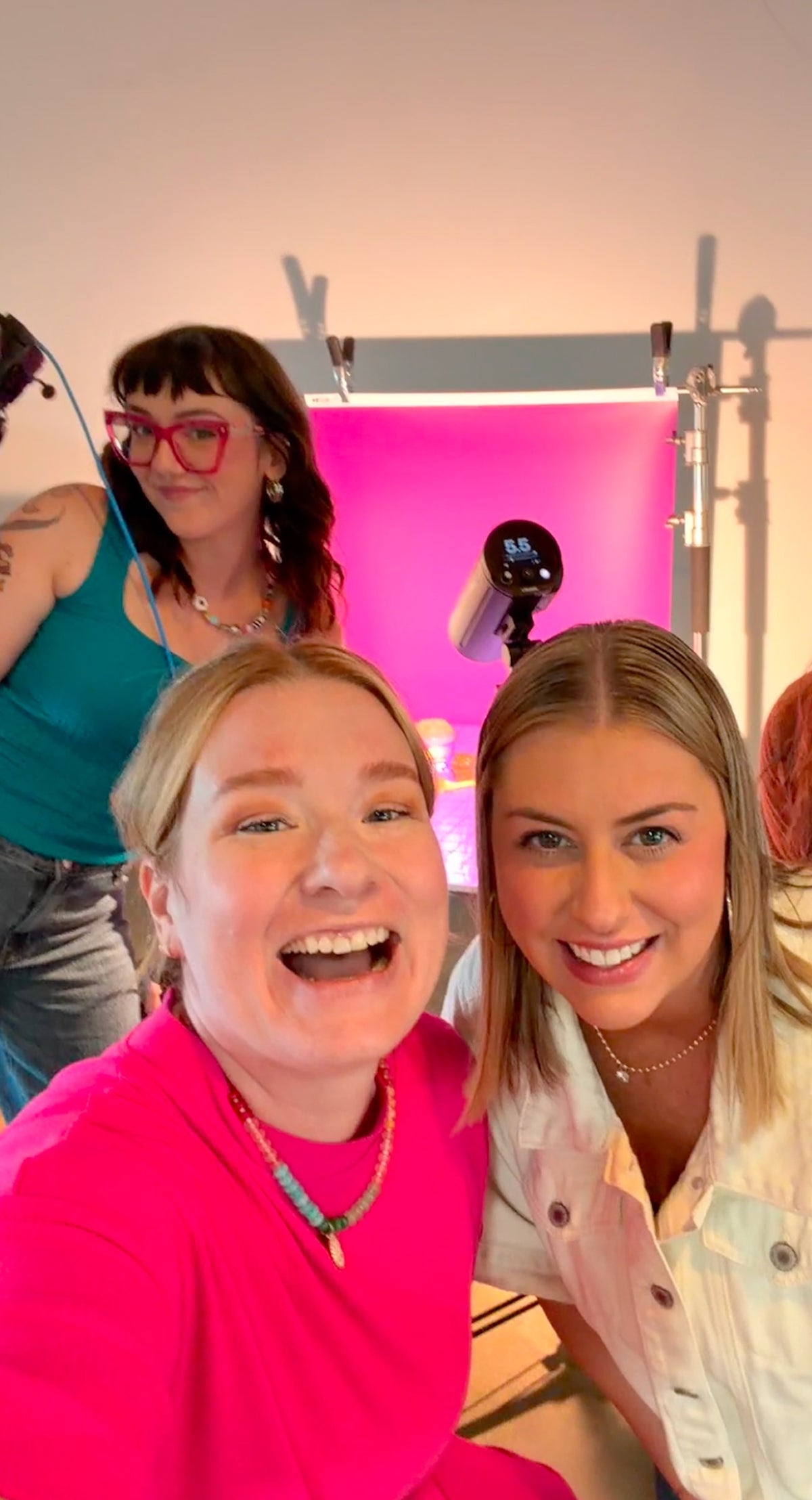 PiiPER team members smiling for a selfie during a colorful studio shoot