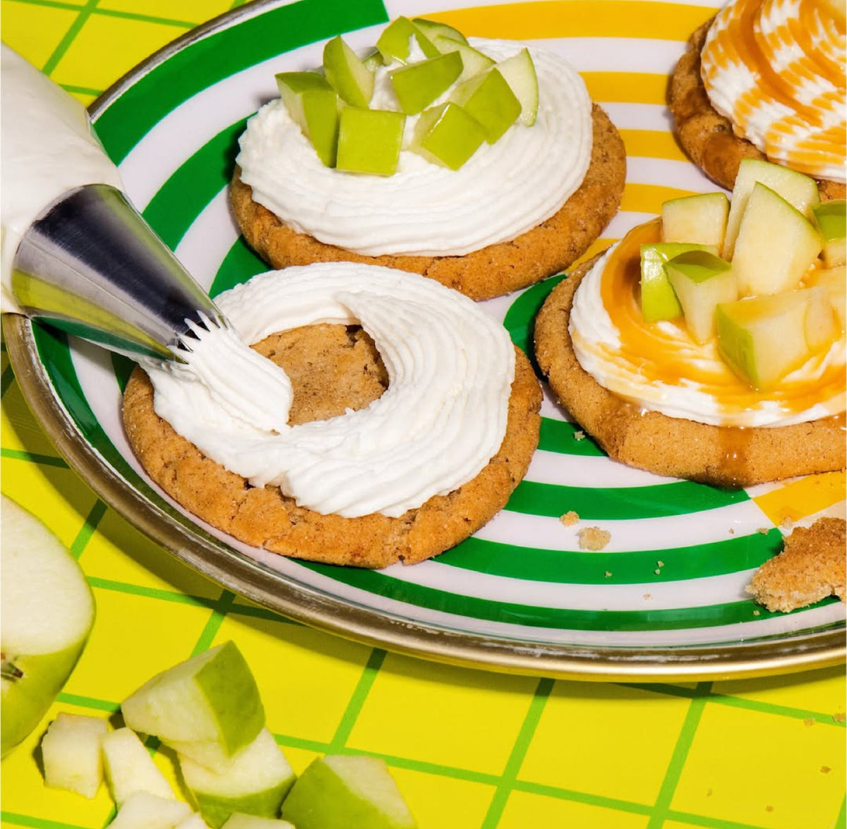 Cookies topped with PiiPER caramel apple buttercream frosting and fresh apple