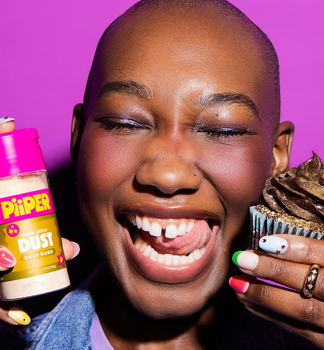Person smiling while holding PiiPER edible glitter dust and a decorated cupcake